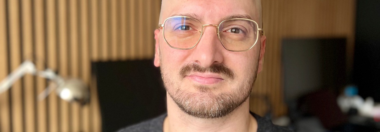 Porträt eines Mannes im Büro mit modernem Hintergrund – Leitsatz: KI ersetzt keine Menschen, sondern übernimmt Aufgaben, die Menschen nicht mehr tun wollen