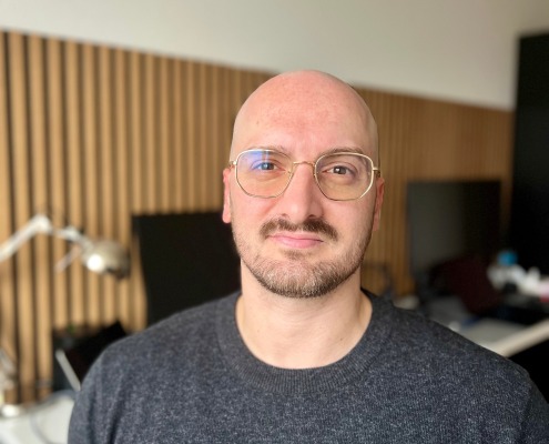 Porträt eines Mannes im Büro mit modernem Hintergrund – Leitsatz: KI ersetzt keine Menschen, sondern übernimmt Aufgaben, die Menschen nicht mehr tun wollen